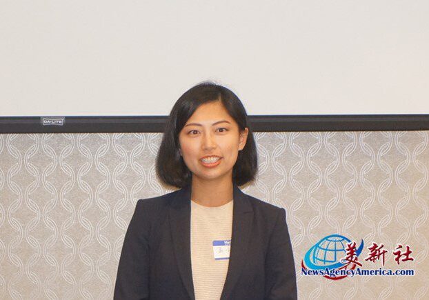 A woman in a suit standing next to a wall.