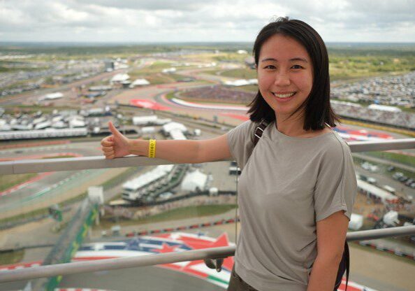 A woman standing on top of a building near a road.